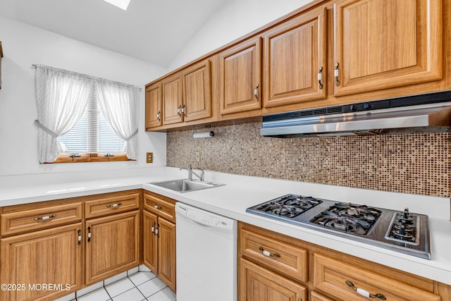 kitchen featuring white dishwasher, a sink, light countertops, stainless steel gas stovetop, and under cabinet range hood