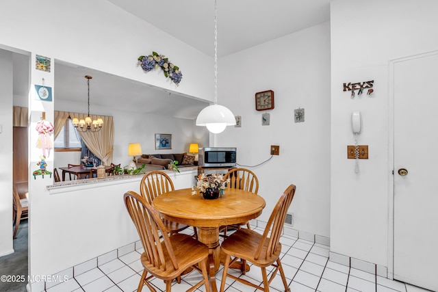 dining space featuring an inviting chandelier and light tile patterned flooring