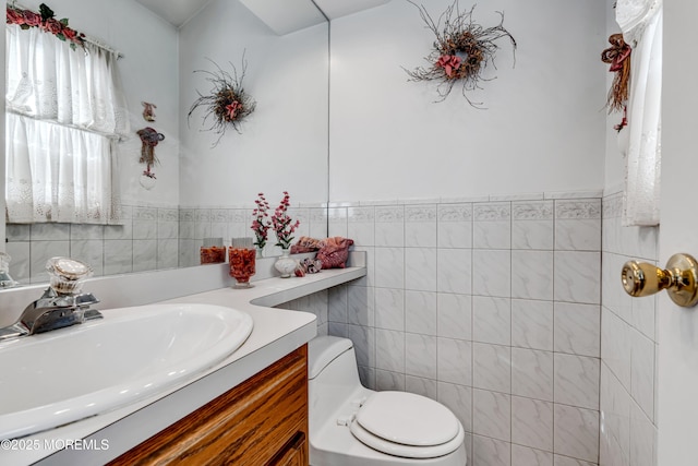 bathroom with toilet, tile walls, and vanity