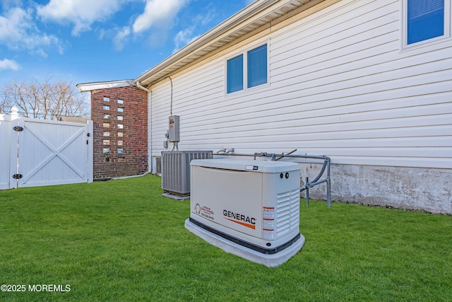 exterior space with cooling unit, fence, a lawn, and a gate