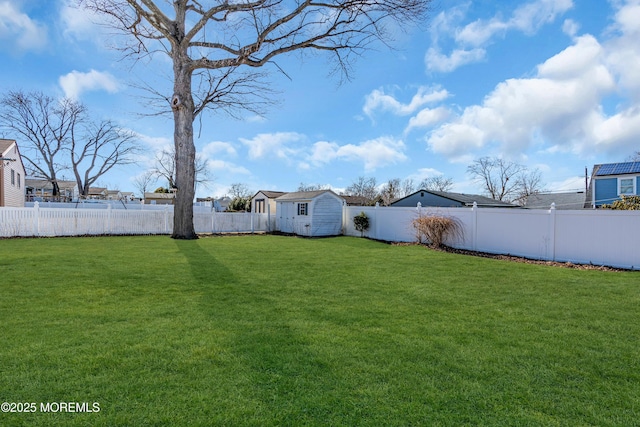 view of yard featuring a shed, an outdoor structure, and a fenced backyard