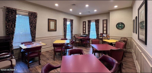 living room featuring visible vents, wood finished floors, wainscoting, and crown molding