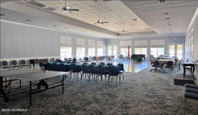 dining room featuring crown molding, carpet, a raised ceiling, and ceiling fan