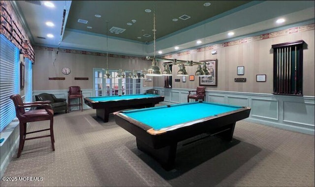 recreation room with a decorative wall, carpet flooring, visible vents, and a tray ceiling