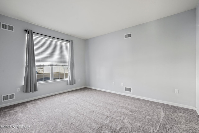 carpeted empty room featuring baseboards and visible vents