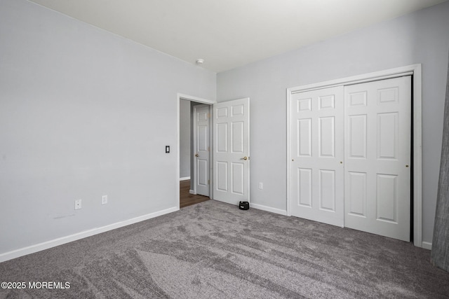 unfurnished bedroom with carpet flooring, baseboards, and a closet