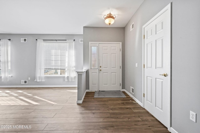 entrance foyer with wood finished floors, visible vents, and baseboards