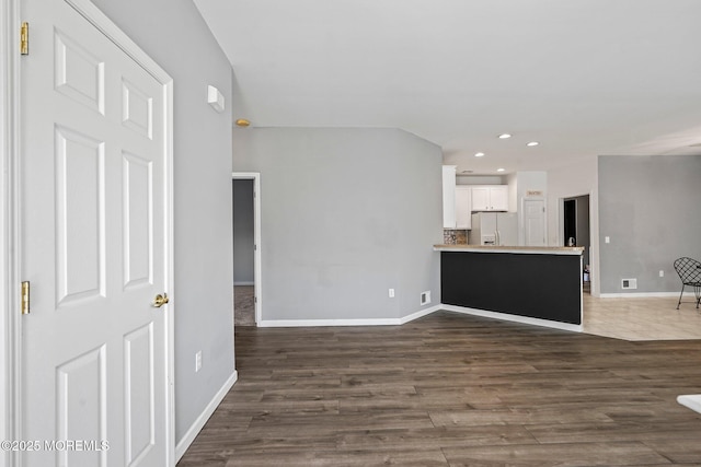 unfurnished living room with recessed lighting, baseboards, and dark wood-style floors