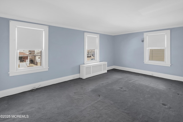 unfurnished room featuring ornamental molding, radiator heating unit, baseboards, and dark colored carpet