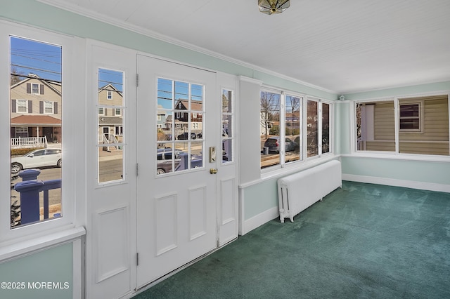 unfurnished sunroom featuring radiator heating unit and a healthy amount of sunlight