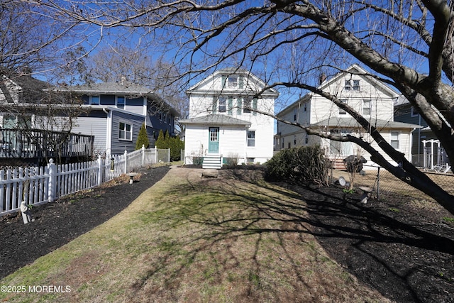 rear view of house featuring entry steps and fence