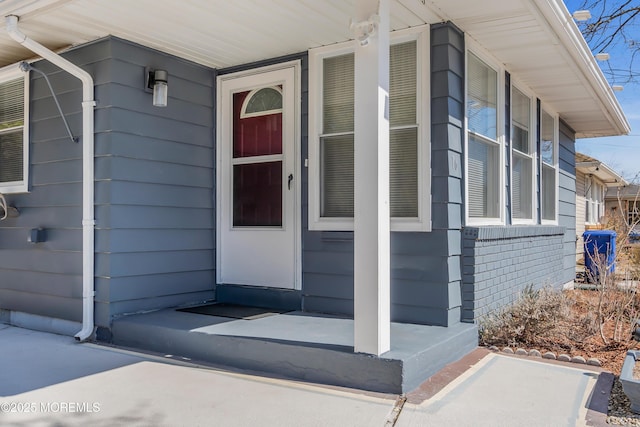 view of exterior entry featuring covered porch