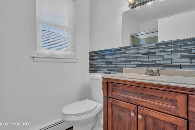 bathroom featuring toilet, vanity, and a baseboard radiator