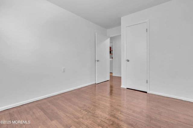 empty room with baseboards and wood finished floors