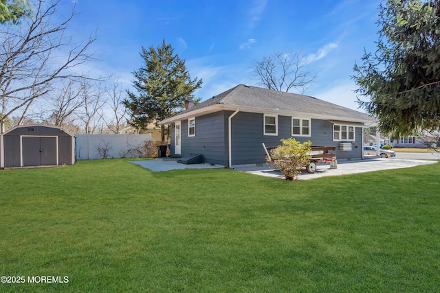 back of property with an outbuilding, a storage unit, a yard, and fence