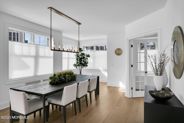 dining area featuring light wood-style floors and baseboards