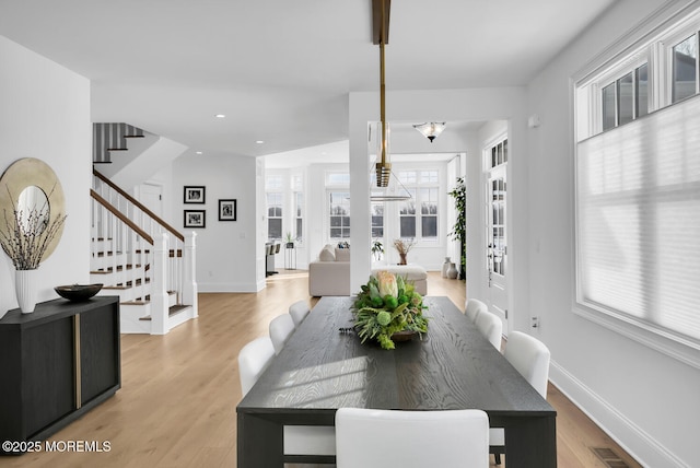 dining space with light wood finished floors, visible vents, baseboards, stairs, and recessed lighting