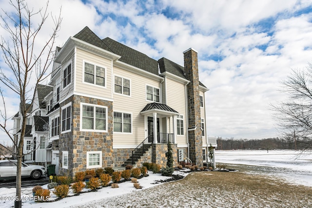 view of front of house featuring stone siding and a chimney