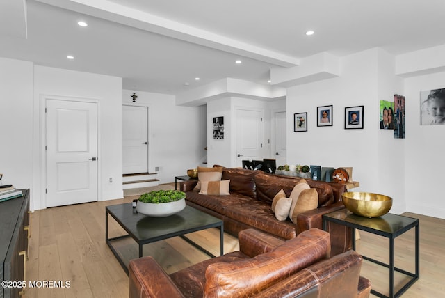 living area featuring beam ceiling, recessed lighting, light wood-type flooring, and baseboards