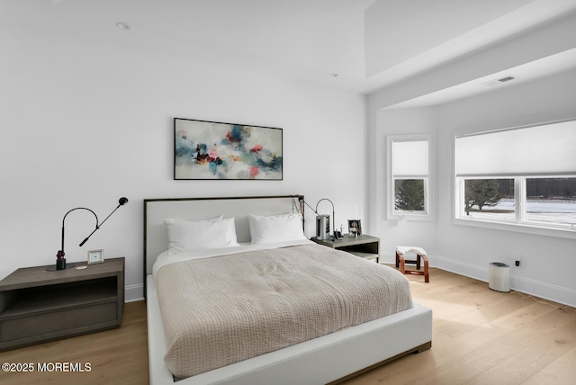 bedroom featuring visible vents, wood finished floors, and baseboards