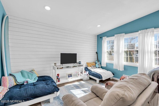 living room with wooden walls, recessed lighting, lofted ceiling, and wood finished floors