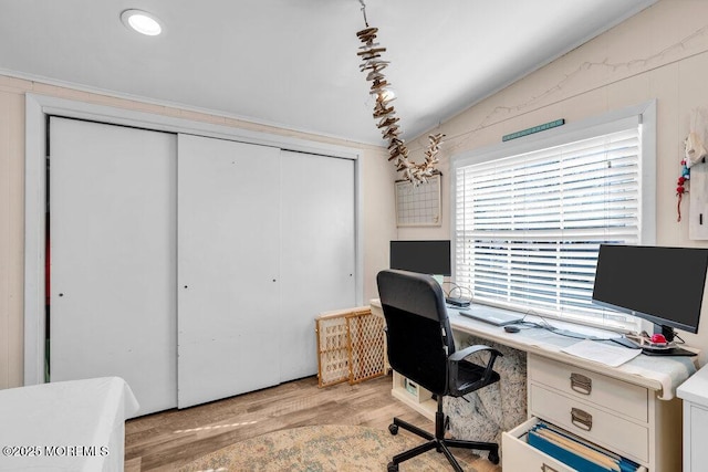 office with light wood-type flooring and vaulted ceiling