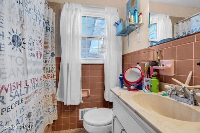 bathroom featuring visible vents, toilet, vanity, a shower with curtain, and tile walls