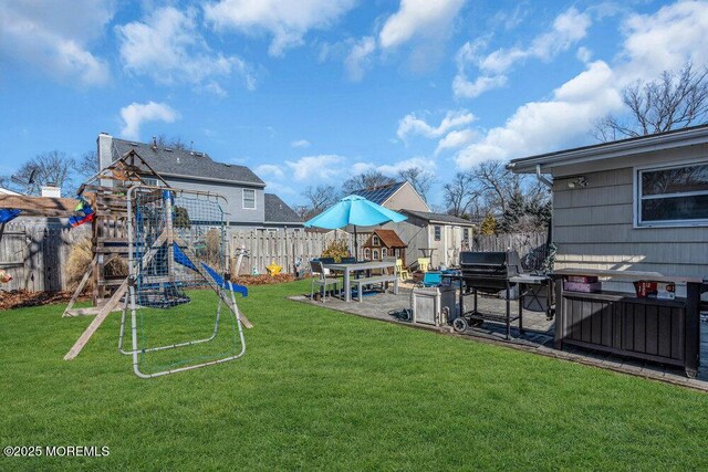 view of yard with a patio area, a fenced backyard, and a playground