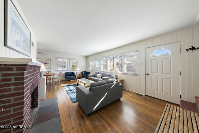 living area with visible vents, a fireplace, and hardwood / wood-style flooring