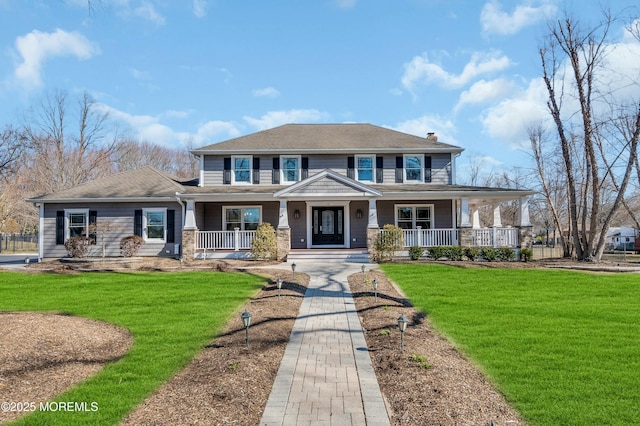 view of front of home with a porch, a front lawn, and a chimney