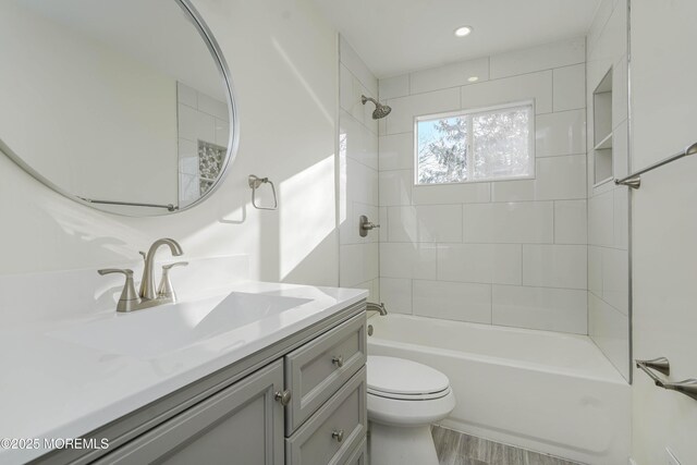 bathroom with bathtub / shower combination, toilet, and vanity