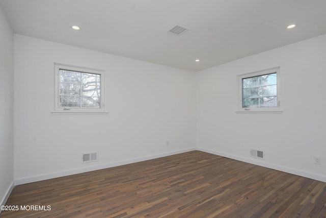 empty room featuring visible vents and wood finished floors