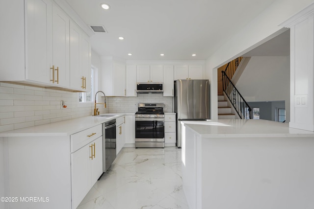 kitchen featuring visible vents, marble finish floor, a sink, stainless steel appliances, and white cabinets