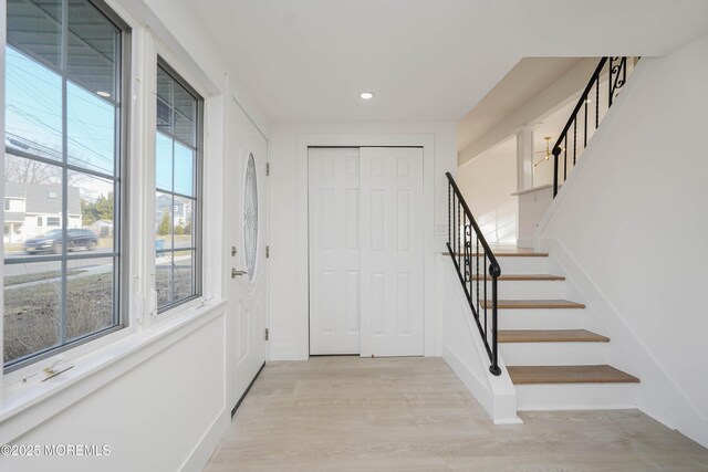 entryway with light wood finished floors, stairway, recessed lighting, and baseboards