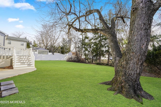 view of yard featuring fence and a wooden deck