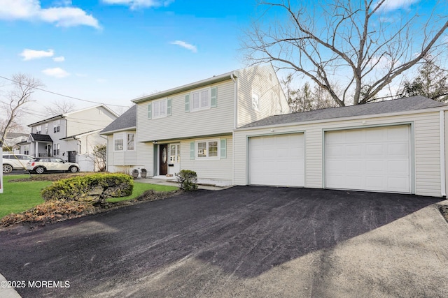 colonial inspired home featuring a residential view, an attached garage, and driveway