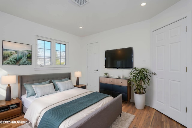 bedroom with recessed lighting, visible vents, and wood finished floors