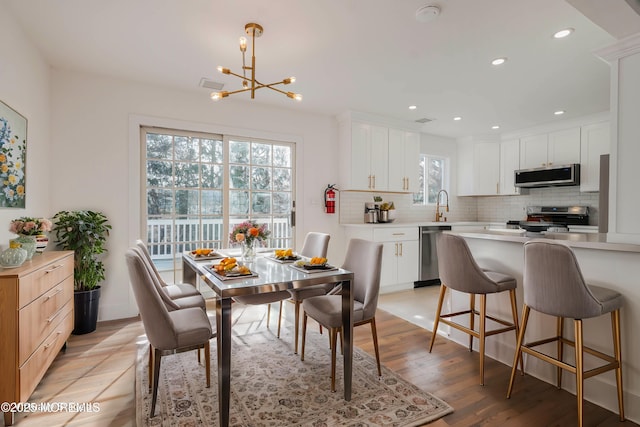 dining room with a notable chandelier, recessed lighting, visible vents, and light wood finished floors