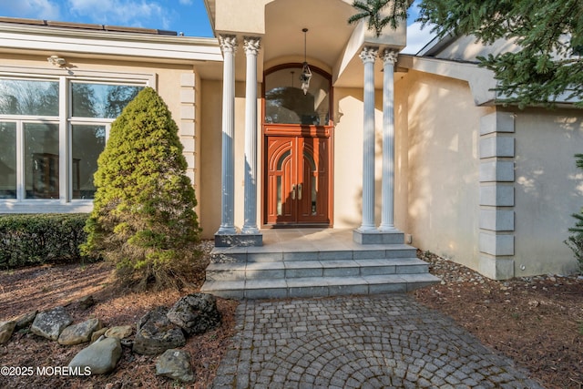 doorway to property featuring stucco siding