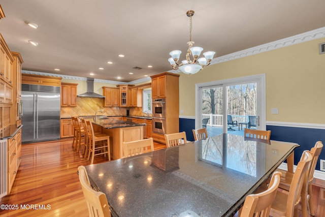 dining area with recessed lighting, a chandelier, ornamental molding, and light wood finished floors