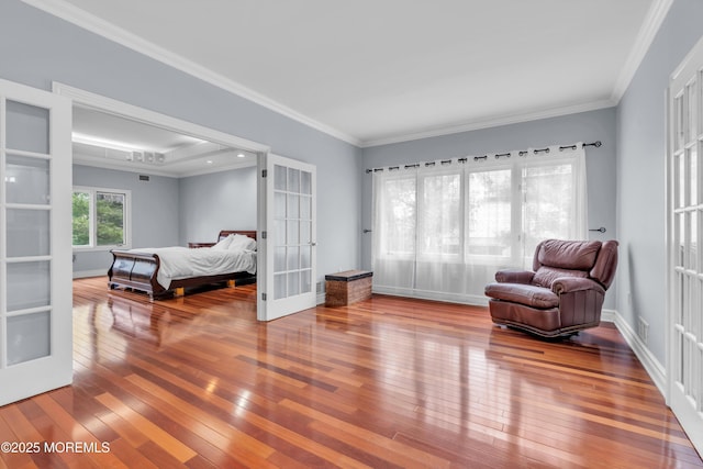 living area featuring visible vents, crown molding, baseboards, french doors, and hardwood / wood-style flooring