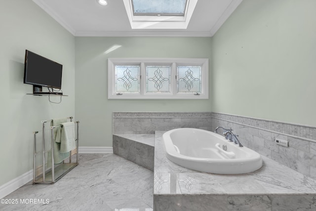 bathroom with marble finish floor, a washtub, a skylight, crown molding, and baseboards