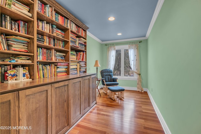 living area with crown molding, recessed lighting, light wood-style floors, and baseboards