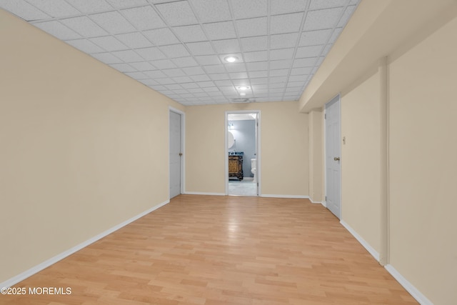 spare room featuring recessed lighting, baseboards, light wood-type flooring, and a drop ceiling