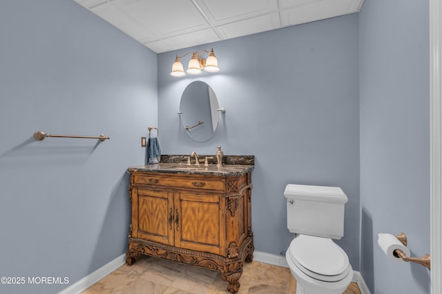 bathroom featuring baseboards, toilet, and vanity