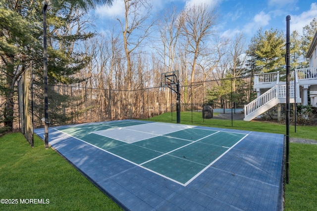 view of basketball court with a yard, basketball court, stairs, and fence