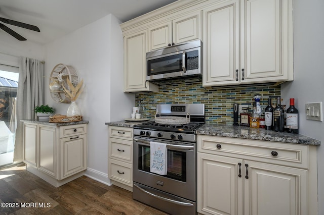 kitchen featuring decorative backsplash, dark stone counters, dark wood-style floors, and appliances with stainless steel finishes