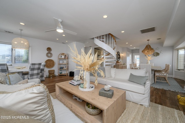 living room featuring recessed lighting, visible vents, wood finished floors, and stairway