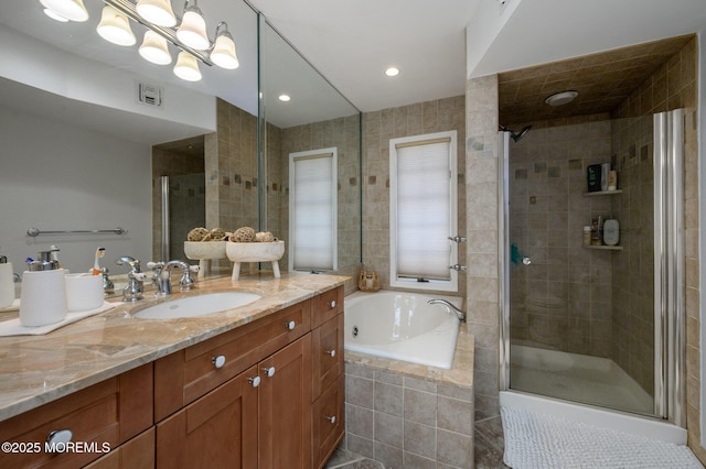 bathroom with visible vents, a stall shower, tile walls, a bath, and vanity