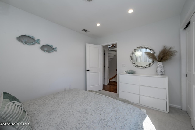 bedroom featuring recessed lighting, light colored carpet, visible vents, and a closet